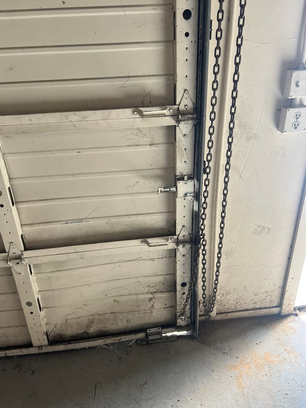 Chain drive opener rail and door sections seen from inside a garage